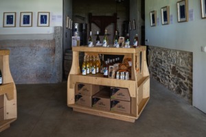 Bouteilles, cartons, et produits de la Tour du Valat exposées sur un meuble élégant dans le chai.